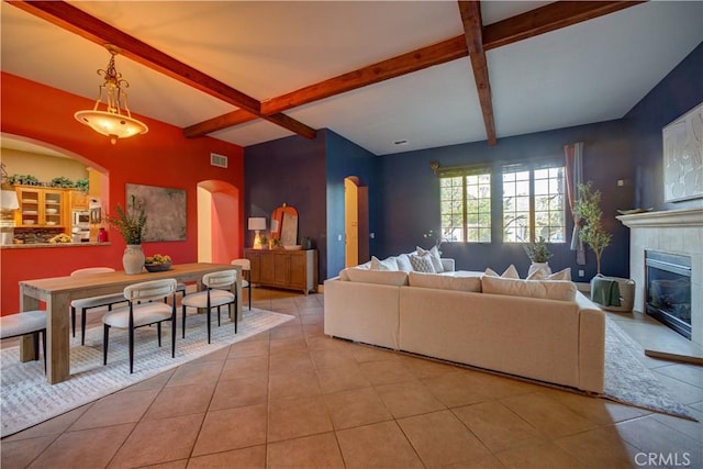 806 Vista Cerro Dr, Paso Robles, CA 93446 - living area featuring arched walkways, a tiled fireplace, tile patterned flooring, beam ceiling, and visible vents