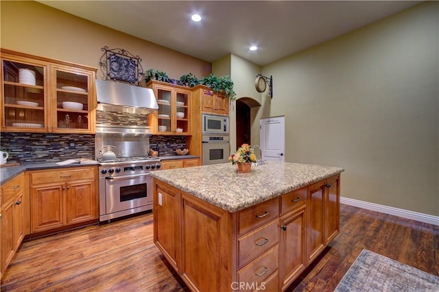 806 Vista Cerro Dr, Paso Robles, CA 93446 - kitchen with dark wood finished floors, ventilation hood, a center island, decorative backsplash, and appliances with stainless steel finishes