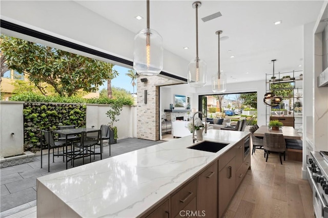 429 Marigold Ave, Corona Del Mar, CA 92625 - kitchen with a sink, stainless steel appliances, light stone counters, open floor plan, and hanging light fixtures