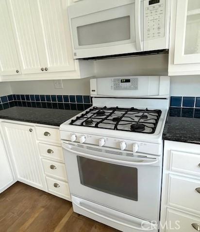 kitchen featuring white appliances, white cabinets, and dark wood-style flooring