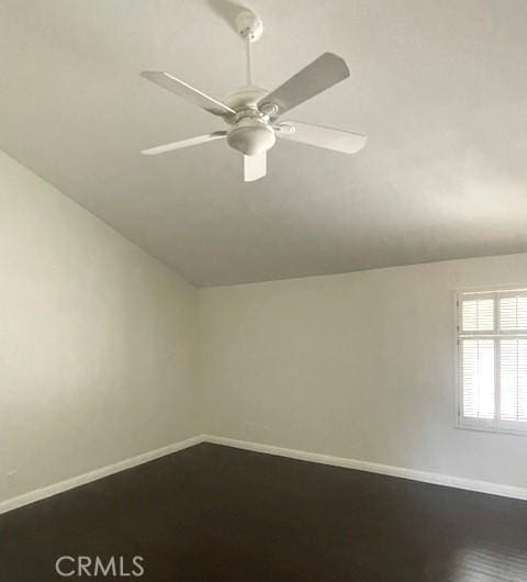 spare room featuring a ceiling fan, vaulted ceiling, and baseboards