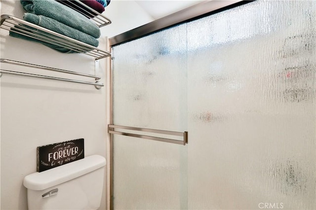 full bathroom with toilet and a stall shower