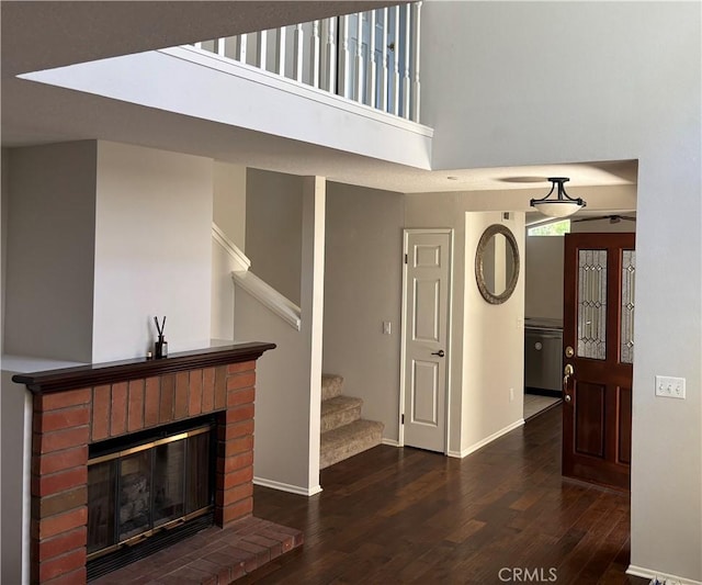 3014 Enrique Unit 98, San Clemente, CA 92673 - unfurnished living room with wood finished floors, stairway, a fireplace, and a towering ceiling