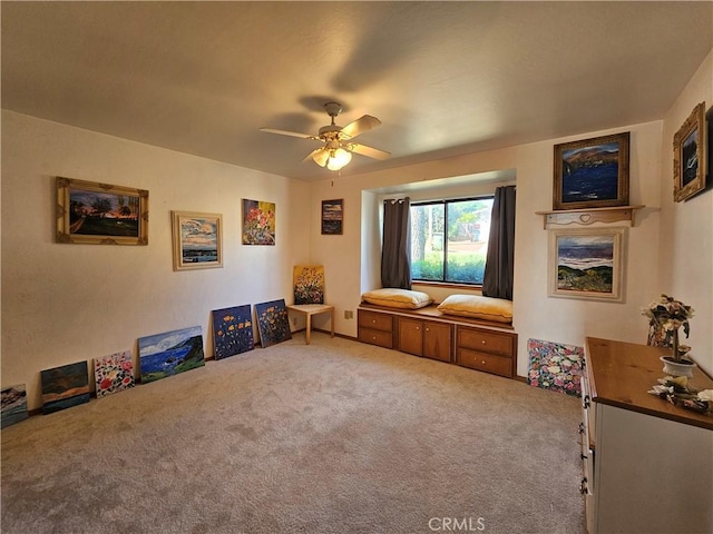 sitting room featuring a ceiling fan and carpet floors