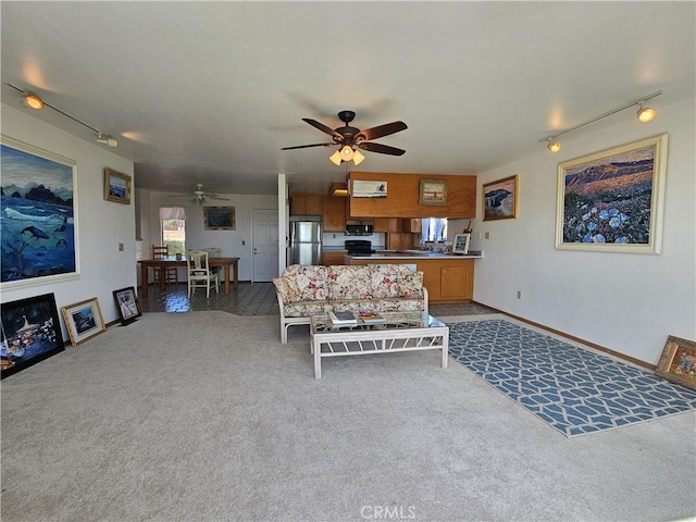 living area with rail lighting, baseboards, a ceiling fan, and carpet flooring