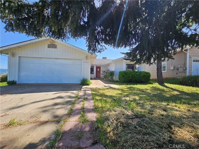 ranch-style home with an attached garage, driveway, and a front lawn