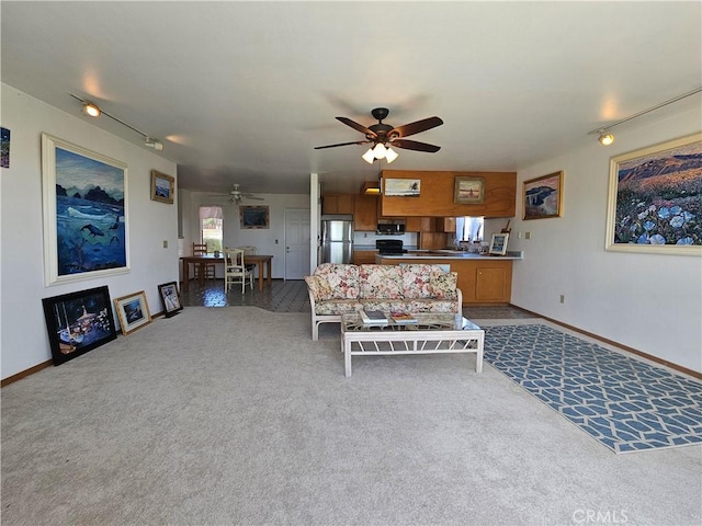 living area with carpet floors, a ceiling fan, and baseboards