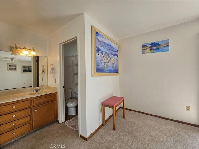 bathroom with baseboards, toilet, vanity, and carpet