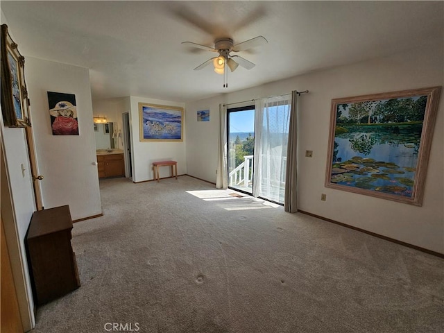 carpeted empty room with ceiling fan and baseboards