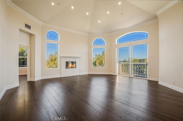 unfurnished living room with high vaulted ceiling, recessed lighting, hardwood / wood-style floors, a glass covered fireplace, and baseboards