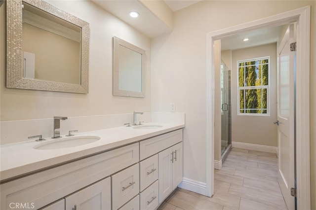 bathroom featuring baseboards, double vanity, a stall shower, and recessed lighting