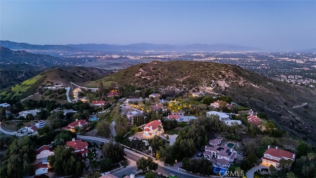 aerial overview of property's location with a mountain backdrop and nearby suburban area