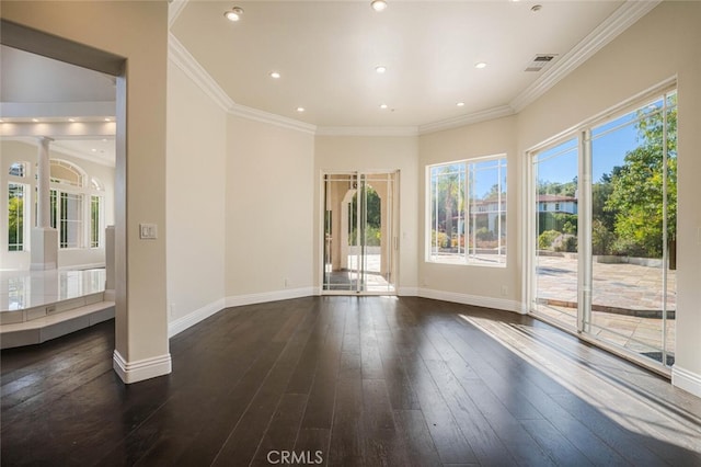 spare room featuring ornate columns, dark wood-style floors, baseboards, recessed lighting, and ornamental molding