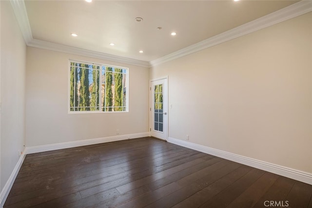 empty room with dark wood finished floors, baseboards, ornamental molding, and recessed lighting