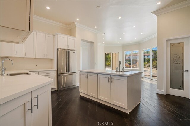 kitchen featuring high quality fridge, a sink, dark wood-style floors, recessed lighting, and crown molding