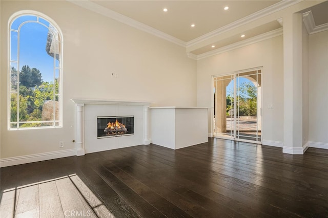unfurnished living room featuring hardwood / wood-style floors, crown molding, a fireplace, recessed lighting, and baseboards