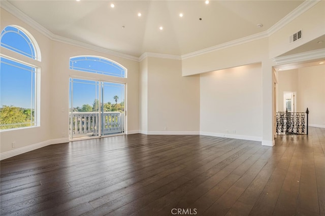 unfurnished living room with a towering ceiling, dark wood-style floors, baseboards, recessed lighting, and ornamental molding