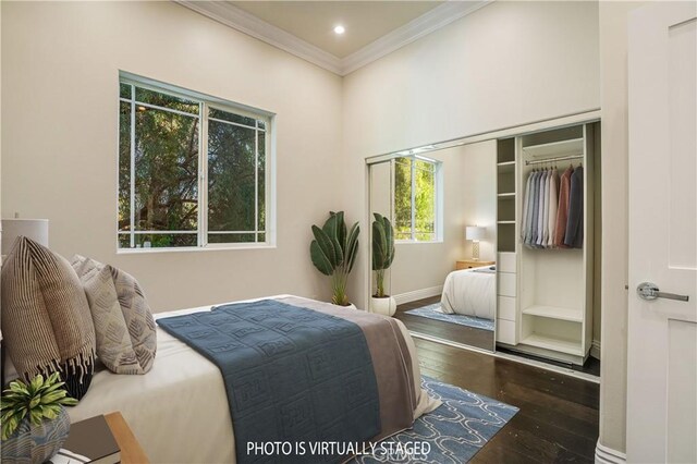 bedroom featuring crown molding, wood-type flooring, a closet, and baseboards