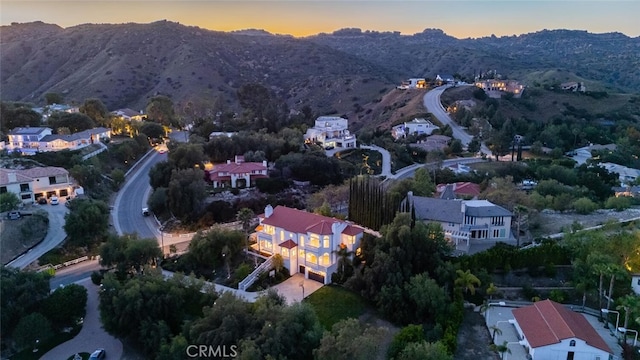 aerial overview of property's location featuring a mountain backdrop and nearby suburban area