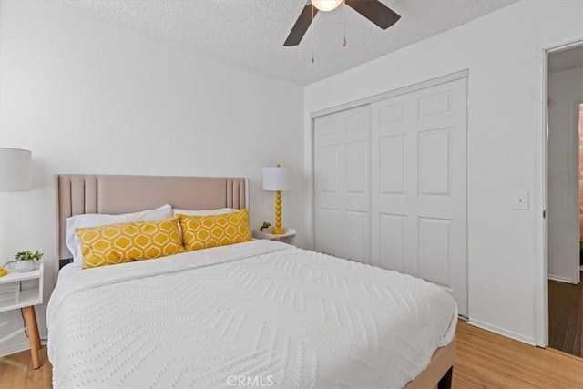 bedroom with a ceiling fan, wood finished floors, a textured ceiling, and a closet