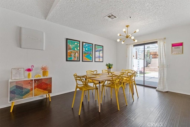 dining room with wood finished floors, visible vents, baseboards, a textured ceiling, and a notable chandelier