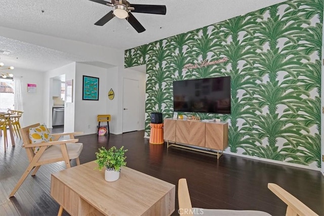 living area featuring wallpapered walls, wood finished floors, a textured ceiling, and a ceiling fan