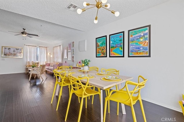 dining space with wood finished floors, a chandelier, a textured ceiling, and visible vents