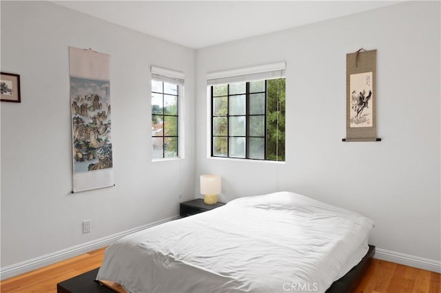 bedroom featuring light wood-style floors and baseboards