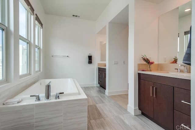 6222 Artisan Way, San Diego, CA 92130 - bathroom featuring a bath, visible vents, two vanities, a sink, and baseboards