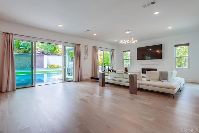 6222 Artisan Way, San Diego, CA 92130 - living room featuring a chandelier, baseboards, visible vents, and light wood-style flooring