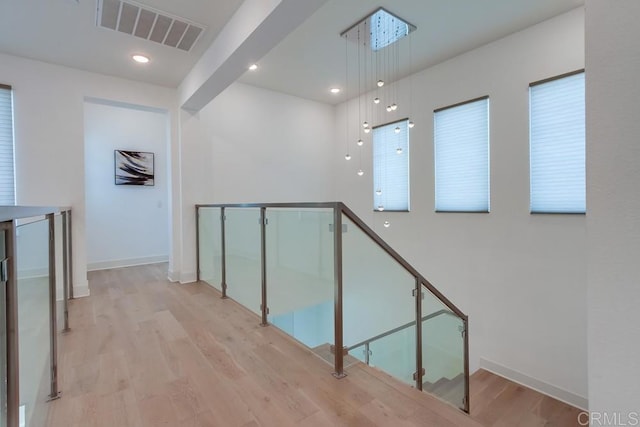 6222 Artisan Way, San Diego, CA 92130 - hall featuring baseboards, visible vents, an upstairs landing, and light wood-style floors