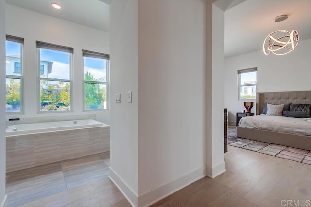 6222 Artisan Way, San Diego, CA 92130 - bathroom featuring baseboards, a chandelier, wood finished floors, and a bath
