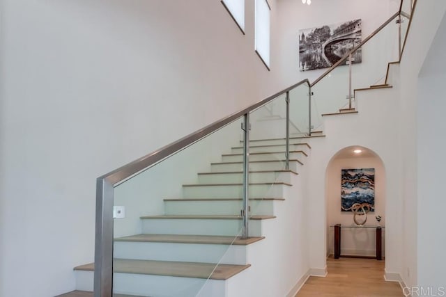 6222 Artisan Way, San Diego, CA 92130 - staircase with wood finished floors, arched walkways, and a high ceiling