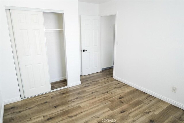 342434241/2 Paloma St, Los Angeles, CA 90011 - unfurnished bedroom with wood finished floors, baseboards, and a closet