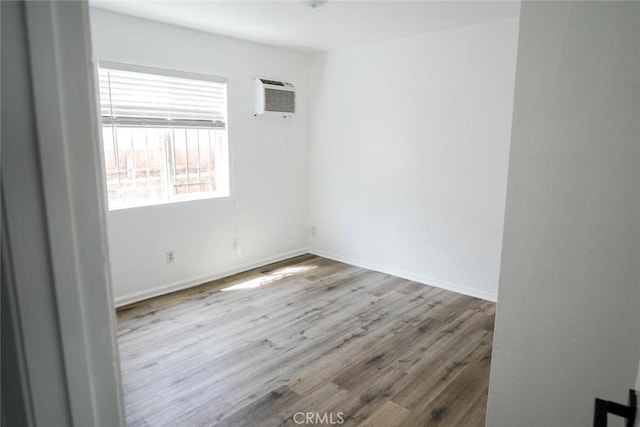342434241/2 Paloma St, Los Angeles, CA 90011 - empty room featuring a wall unit AC, wood finished floors, and baseboards