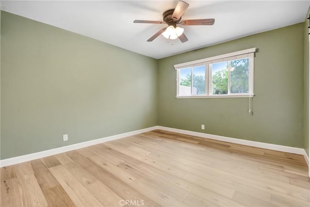 spare room featuring baseboards, a ceiling fan, and light wood-style floors