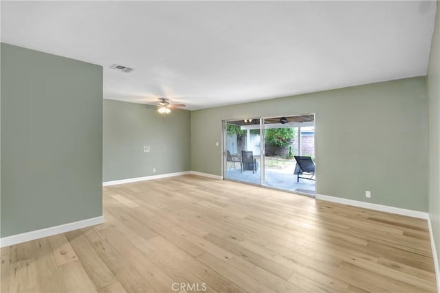 empty room featuring ceiling fan, baseboards, and light wood-type flooring