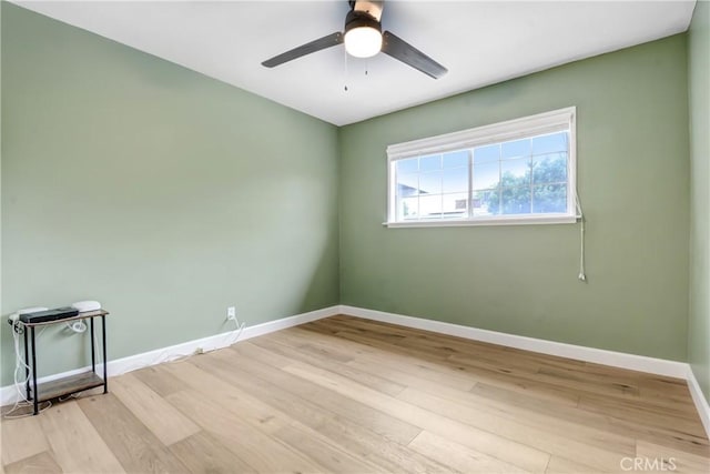 empty room with baseboards, light wood finished floors, and a ceiling fan