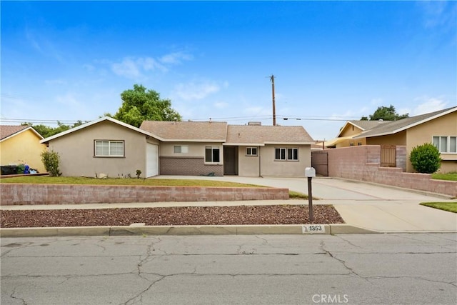 ranch-style house with stucco siding, fence, and driveway