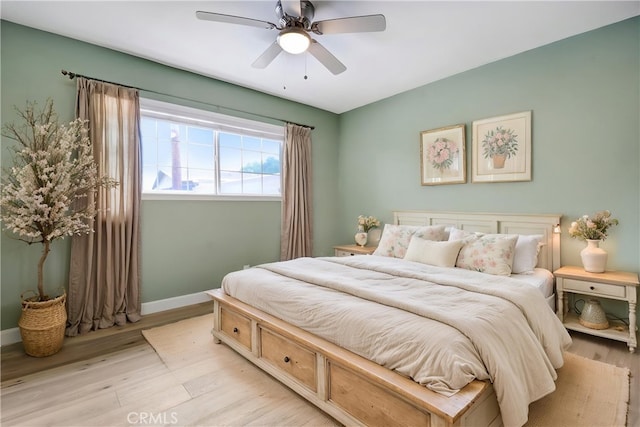 bedroom featuring light wood-style floors, baseboards, and a ceiling fan
