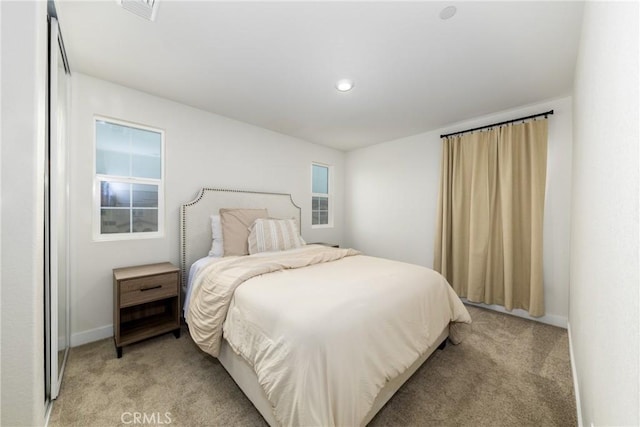 bedroom featuring baseboards, visible vents, and light colored carpet