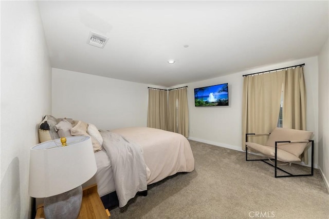 bedroom with baseboards, visible vents, and light colored carpet
