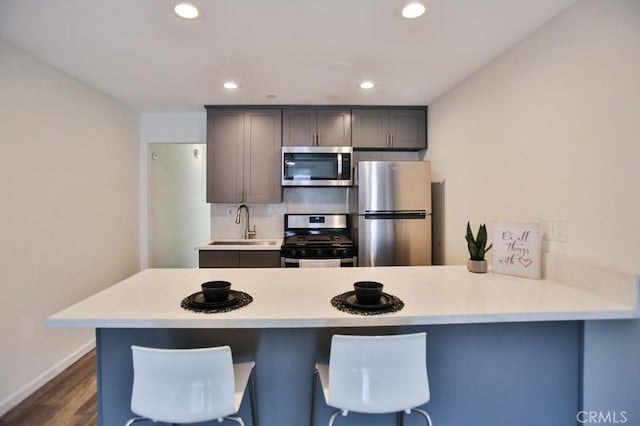 17200 Newhope St Unit 206, Fountain Valley, CA 92708 - kitchen featuring stainless steel appliances, a peninsula, light countertops, recessed lighting, and dark wood finished floors