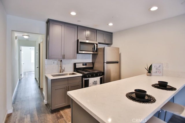 17200 Newhope St Unit 206, Fountain Valley, CA 92708 - kitchen featuring appliances with stainless steel finishes, a peninsula, gray cabinetry, a kitchen bar, and light countertops