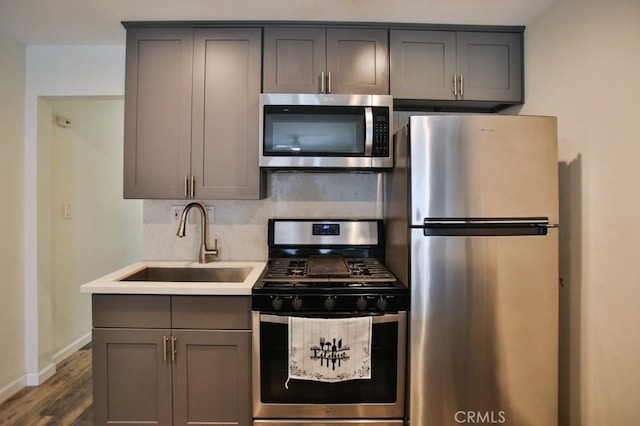 17200 Newhope St Unit 206, Fountain Valley, CA 92708 - kitchen with appliances with stainless steel finishes, gray cabinets, backsplash, light countertops, and dark wood-style flooring