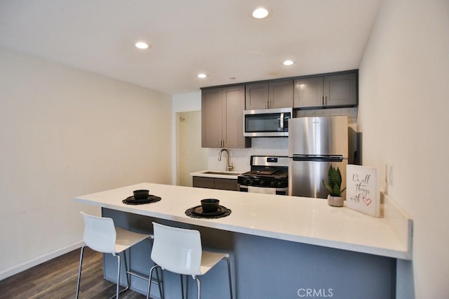 17200 Newhope St Unit 206, Fountain Valley, CA 92708 - kitchen with stainless steel appliances, a peninsula, dark wood-style floors, recessed lighting, and light countertops