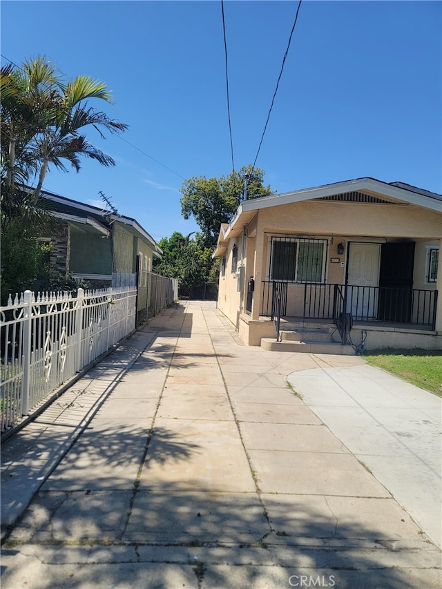 6221 Fishburn Ave, Bell, CA 90201 - view of side of home with stucco siding, fence, and a porch