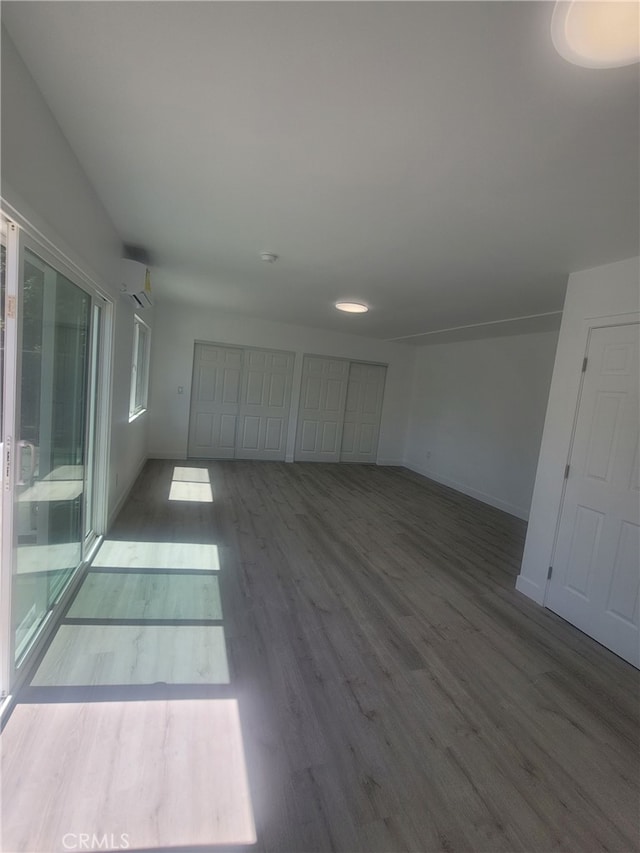6221 Fishburn Ave, Bell, CA 90201 - empty room featuring wood finished floors, baseboards, and a wall mounted AC