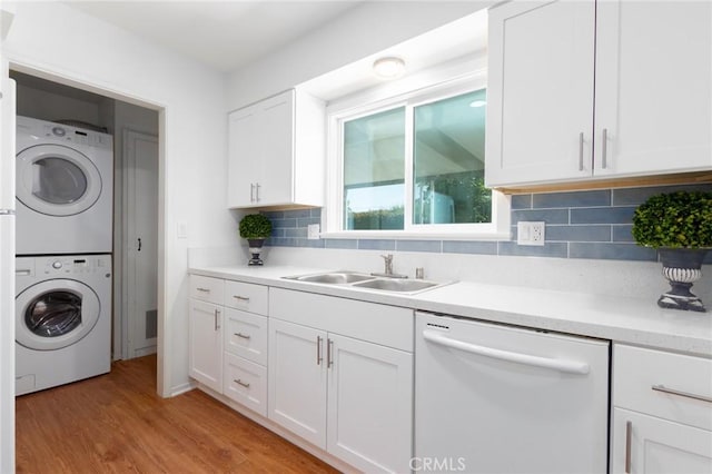 28590 Middlebury Way, Menifee, CA 92586 - laundry room featuring stacked washing machine and dryer, a sink, and light wood-style floors