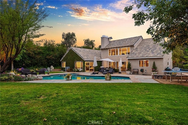 5665 Trailside Dr, Yorba Linda, CA 92887 - back of house at dusk with a chimney, a patio, stucco siding, and an outdoor pool